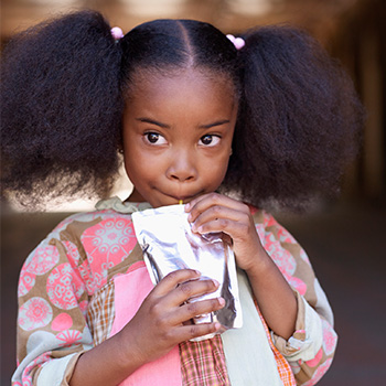 young girl eating an applesauce pouch